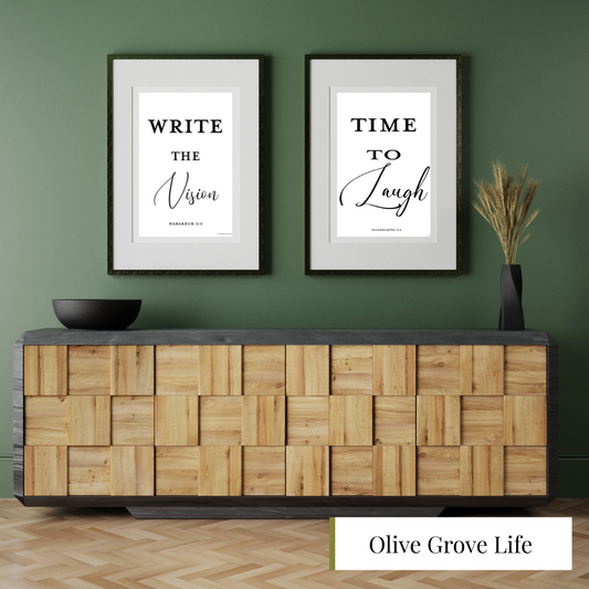 Wooden sideboard with framed prints on a green wall, featuring scripture prints