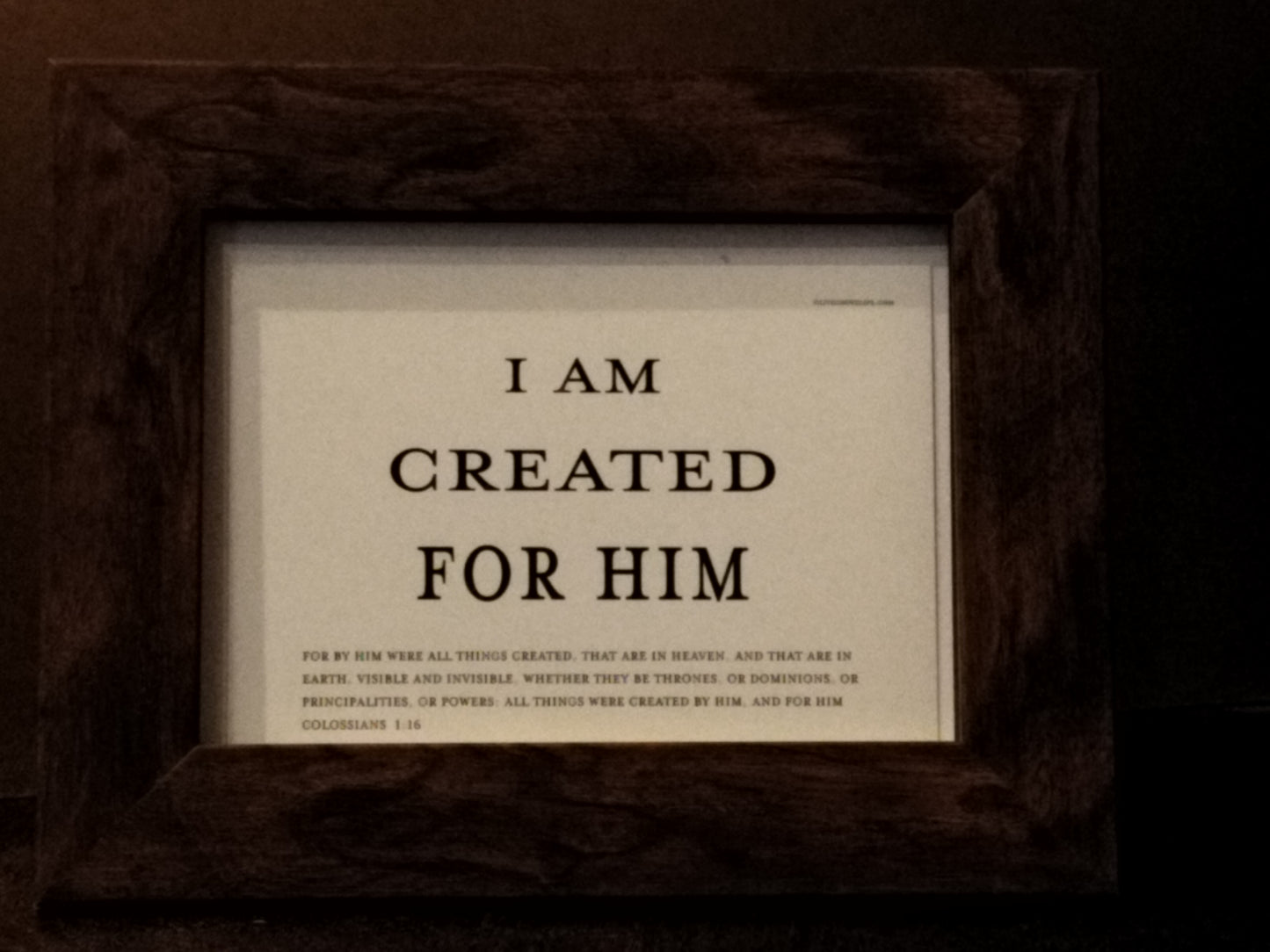 Framed text sign with religious quote on a dark background