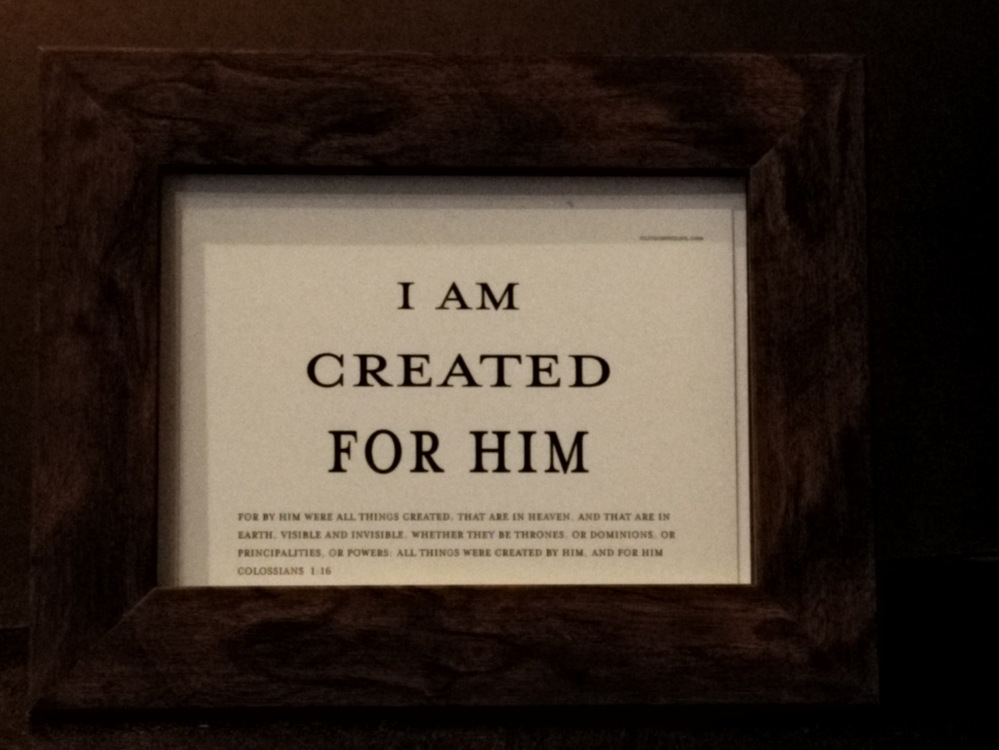Framed text sign with religious quote on a dark background