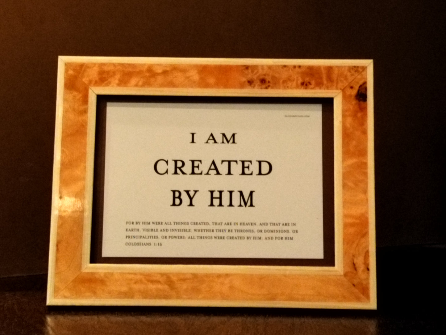Framed quote 'I am created by Him' on a dark background