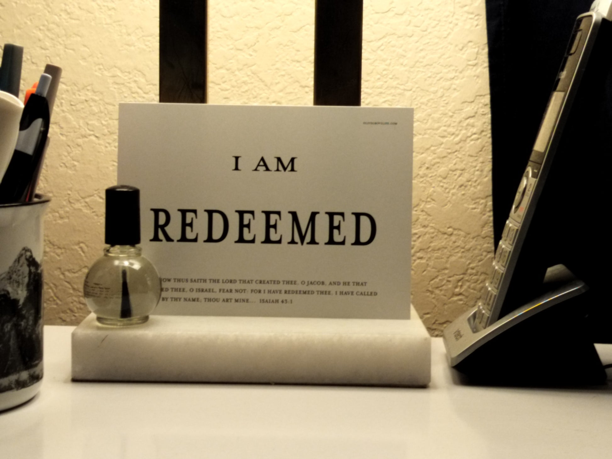 Notebook with 'I AM REDEEMED' text on a desk with stationery items.