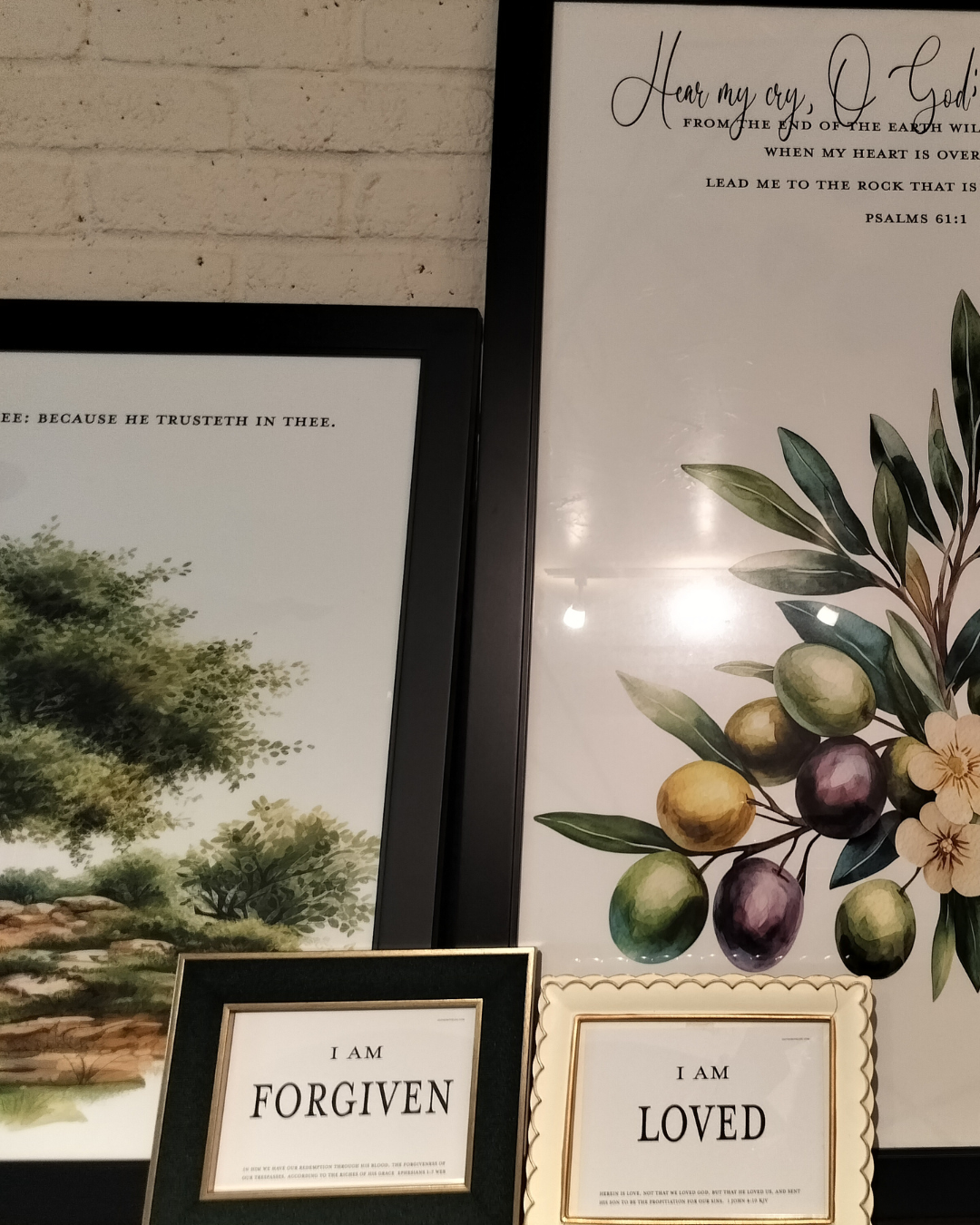 Framed artwork with nature-themed prints and motivational phrases on a wall.