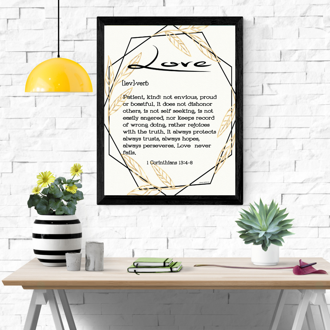 1 Corinthians 13:4-8 Love Defined Art Print hanging over wooden desk with potted plants and books