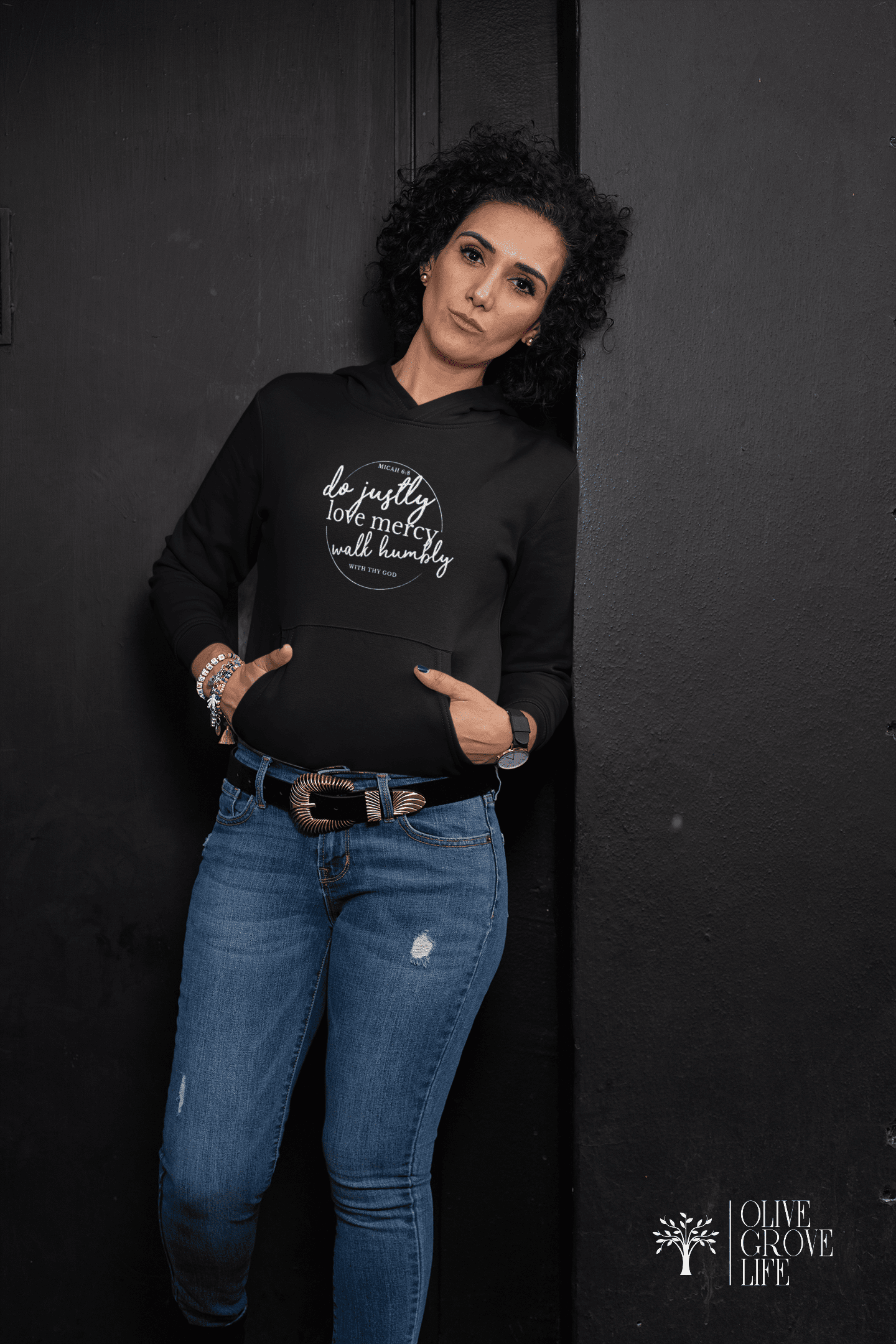 Micah 6:8 do justly, love mercy, act humbly...Unisex Hoodie Black on woman leaning against black wall